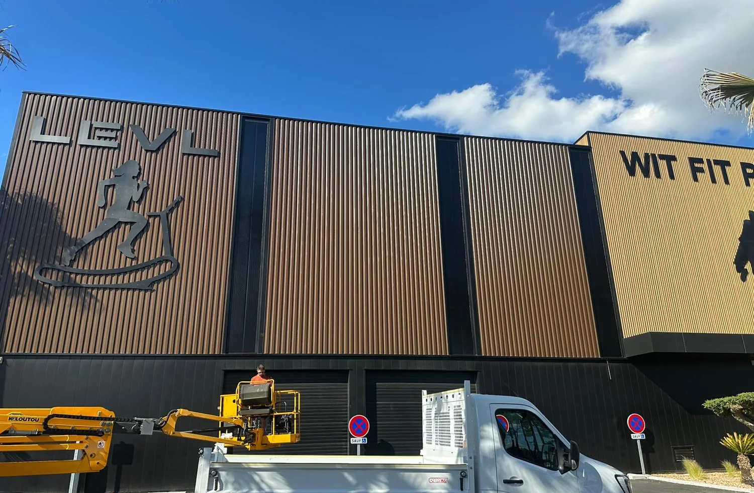 Façade industrielle avec bardage vertical et intervention en nacelle